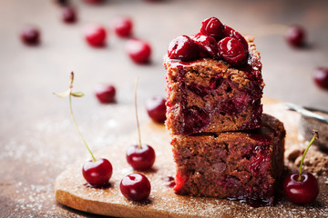 Chocolate brownie decorated with cherry. Homemade cake on wooden table.