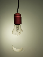 Old style incandescent broken light bulb, hanging. Concept, metaphor.