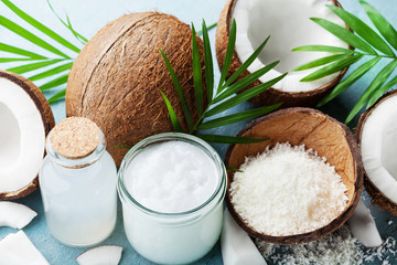 Set of organic coconut products for spa, cosmetic or food ingredients decorated palm leaves. Coconut oil, water and shavings. © juliasudnitskaya