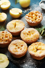 Naklejka na ściany i meble Yummy apple pies decorated sugar powder. Autumn pastry dessert on black board..