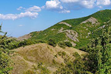 Fototapeta na wymiar high steep grass-covered slope on the blue sky background