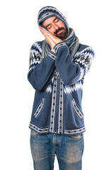 Man with winter clothes making sleep gesture