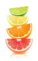 Isolated citrus fruits wedges. Pieces of grapefruit, orange, lemon and lime on top of each other isolated on white background with clipping path