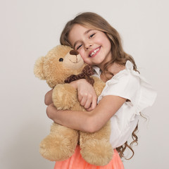 Adorable little girl hugging teddy bear