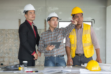 Businessman, engineer, architect and worker team discussing about building plan for construction at job site. Teamwork collaboration relation concept