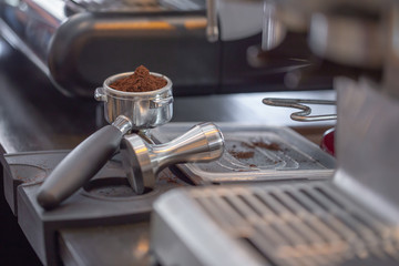 Pressing coffee with tamper before brew. Selective focus
