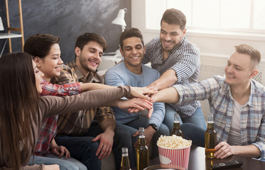 Happy multiracial friends join hands together