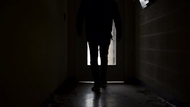 Man walking down a dark brick alley