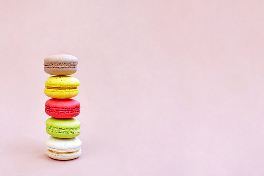 Colorful macaroons or macarons stack on the lemonade color background with space for text, isolated