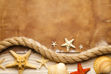 Fototapeta na wymiar Marine background - seashells, hawser, beach sand and blank paper sheet