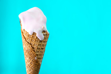 melted ice cream cone on mint blue background