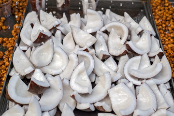 A close-up view of water drops falling on coconut slices at local market