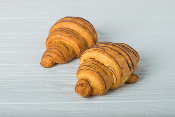 two croissant sprinkled with powdered sugar isolated on a white background closeup