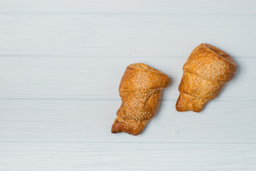 freshly baked croissants and coffee cup on grey table, top view