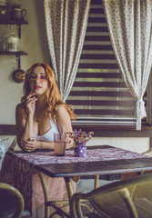 Fashion intimate retro vogue portrait of young red hair model woman near vintage cafe interior 