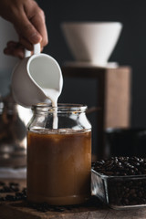 coffee In a glass bottle,Coffee drip,Hand holding a kettle Drip Coffee In the room,Black coffee in glass