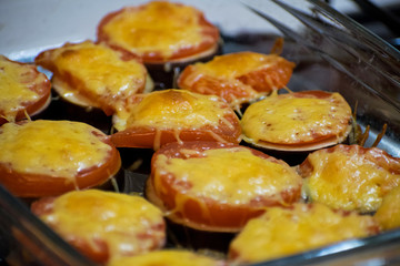 Summer food: hot eggplant with cheese and tomatoes close up. Baked eggplant with tomatoes and cheese.