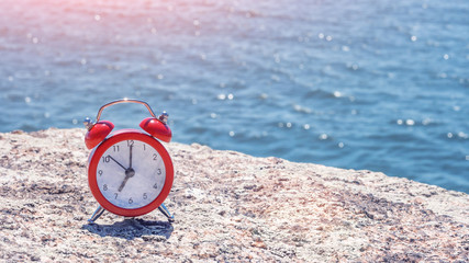 Morning of new day, alarm clock on sea background. sunlight in morning. Health, lifestyle and...