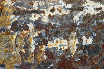 Red, yellow and grey mossy stone surface texture with cracks. Mountain limestone background.