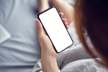 Close up Woman hand Using a Smart Phone on bed at home.
