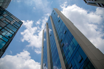 Glass fronted skyscraper with reflections of the sky and clouds in the windows