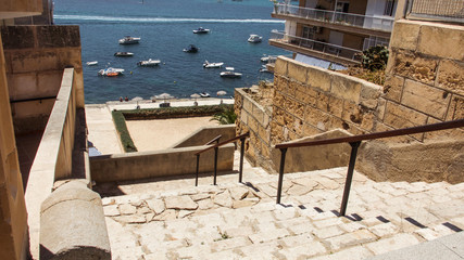Fototapeta na wymiar View between buildings in Santa Ponsa to ships moored in the bay.