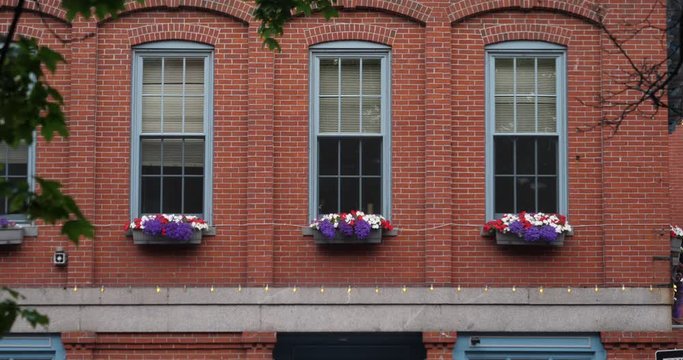 A daytime establishing shot of a typical New England red brick apartment building.  	