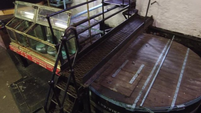 Low wines tubs and open spirit safe at whiskey distillery in Scotland