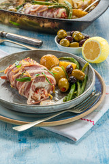 Bacon-wrapped haddock stuffed with crayfish tails, with lemony new potatoes, green beans and olives