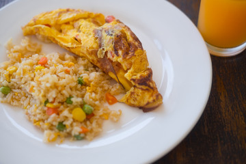 Omelet with fried rice on white dish