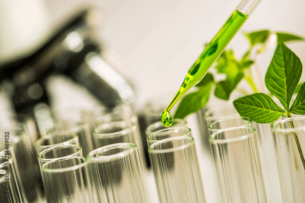 Poster pipette over test tube dropping sample chemical into sample herbal plaint with microscope background