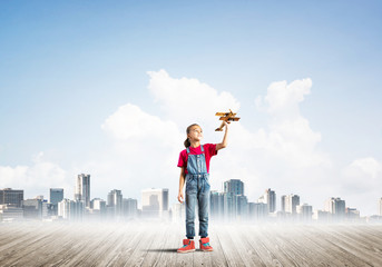 Concept of careless happy childhood with girl dreaming about future