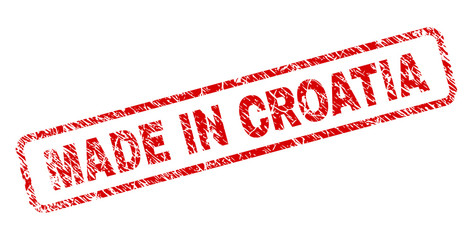 MADE IN CROATIA stamp seal print with distress style. Red vector rubber print of MADE IN CROATIA caption with retro texture. Text caption is placed inside rounded rectangle frame.