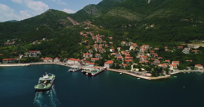 Aerial beautiful view from above to Kotor Bay and regular passenger ferry from Lepetane to Kamenari by a sunny afternoon