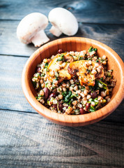 Bamboo bowl of boiled buckwheat with fried champignon, spinach and red beans