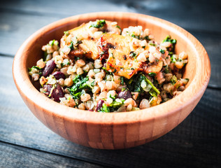 Bamboo bowl of boiled buckwheat with fried champignon, spinach and red beans
