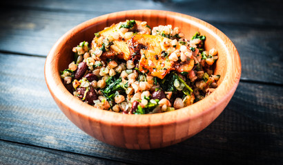 Bamboo bowl of boiled buckwheat with fried champignon, spinach and red beans