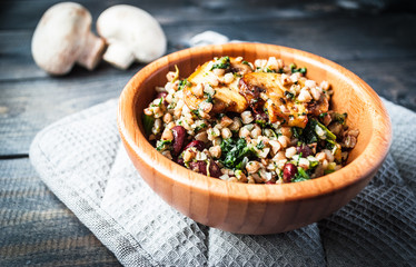 Bamboo bowl of boiled buckwheat with fried champignon, spinach and red beans