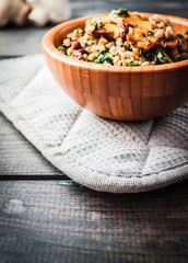Bamboo bowl of boiled buckwheat with fried champignon, spinach and red beans