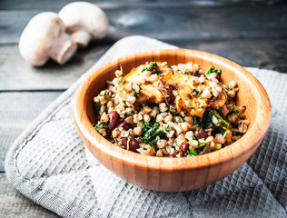 Bamboo bowl of boiled buckwheat with fried champignon, spinach and red beans