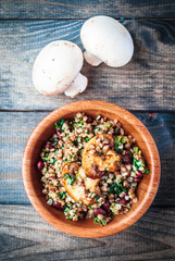 Bamboo bowl of boiled buckwheat with fried champignon, spinach and red beans