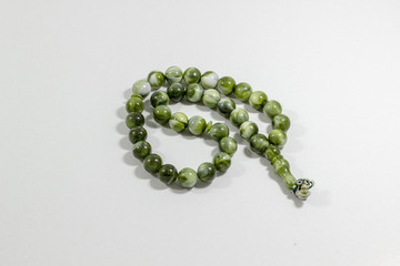 Close-up shot of curved handmade green big stone islamic prayer beads