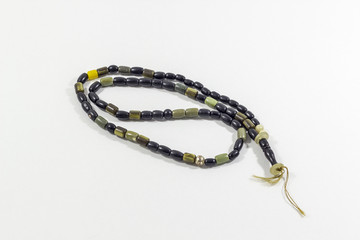 Close-up shot of curved handmade black and green stone islamic prayer beads