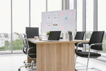Office table with blank notepad and laptop