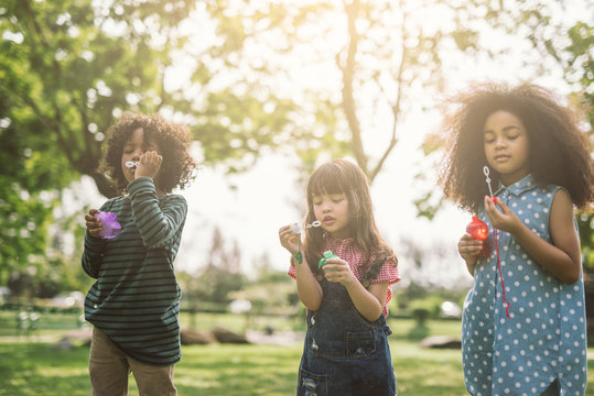 Kids playing Blowing Bubbles Together at the Field