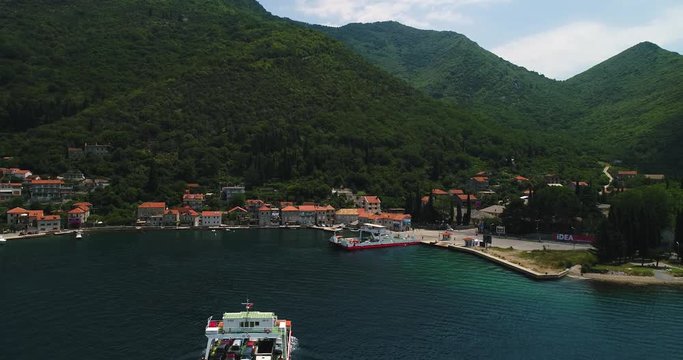 Aerial beautiful view from above to Kotor Bay and regular passenger ferry from Lepetane to Kamenari by a sunny afternoon