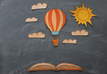 Back to school concept. Hot air balloon cut from paper and painted over classroom blackboard...