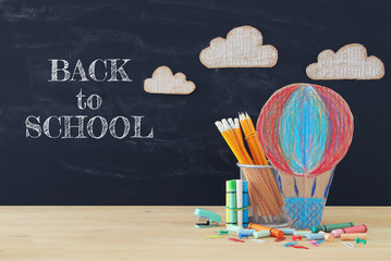 Back to school concept. hot air ballon and pencils in front of classroom blackboard.