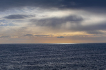 Naklejka na ściany i meble Sunset at sea on a cloudy day