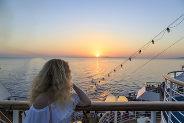 Blonde watching sunset from cruise ship